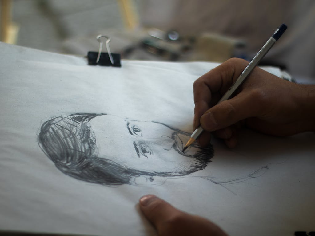 A detailed close-up of a hand skillfully sketching a portrait with a pencil in Srinagar.