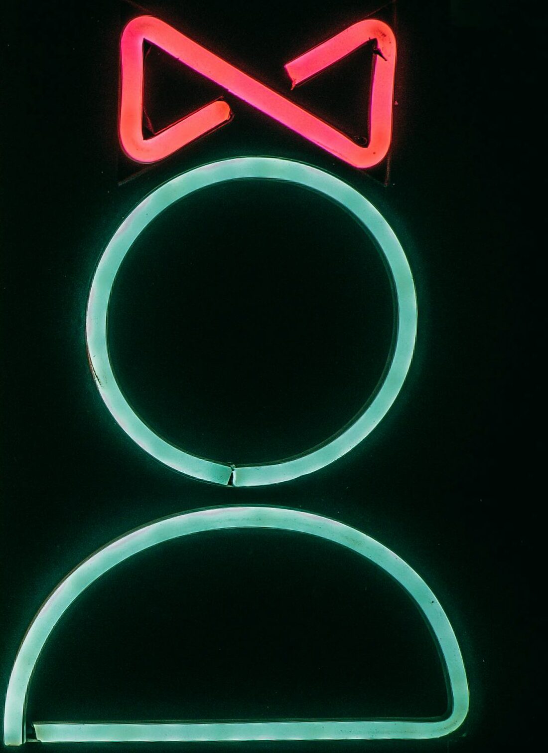 Bright neon bathroom sign with male and female symbols, vibrant and modern.